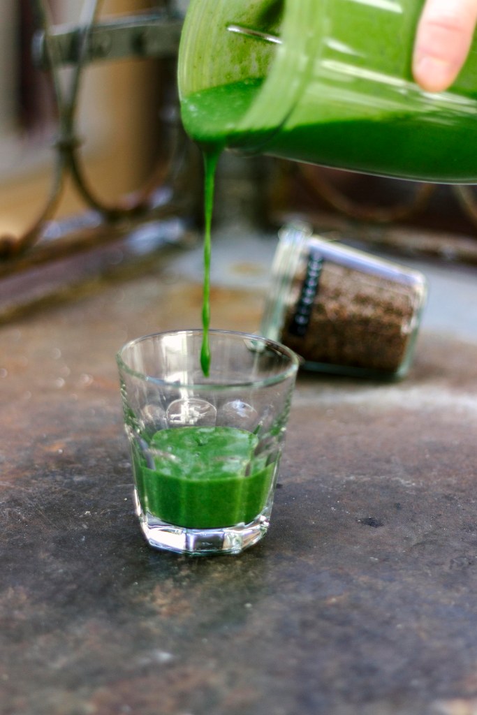 Grüner Smoothie wird in Glas geleert